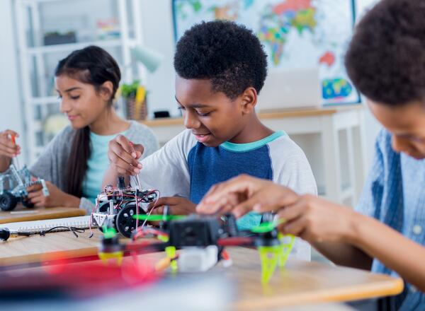 Three youth working on a robotics project